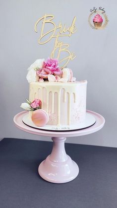 a white cake with pink flowers and the words bridal to be written on top