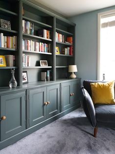 a living room filled with lots of bookshelves next to a couch and window