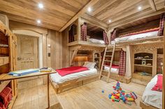 a bedroom with bunk beds and wooden floors in the room, along with toys on the floor