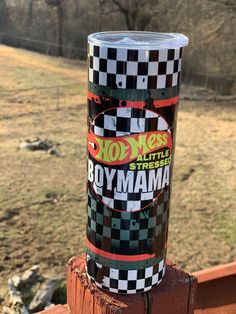 a can of hotdogs sitting on top of a wooden post in front of a field