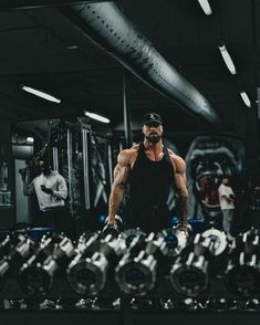 a man working out in the gym with dumbs on his shoulders and one arm behind him