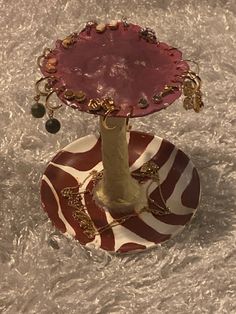 a red and white plate with a tree on it sitting on a tablecloth covered floor