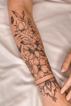 a black and white flower tattoo on the arm