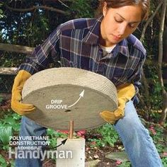 a woman is working with concrete in the garden