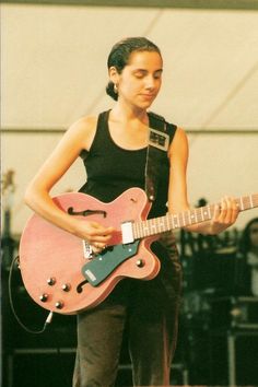 a young woman is playing an electric guitar