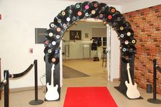 an entrance to a music themed room with vinyl records and guitars on the wall, along with a red carpet