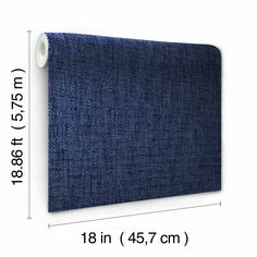 a blue fabric wall hanging on the side of a white wall next to a ruler