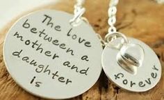 the love between a mother and daughter is forever necklaces on a piece of wood