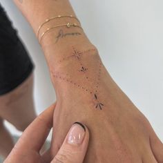 a woman's hand with a small star tattoo on it