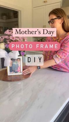 a woman sitting at a counter in front of a vase with flowers on it and the words, mother's day photo frame diy