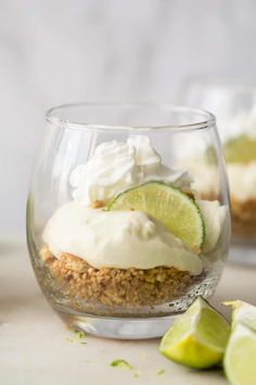 a dessert in a glass with limes and whipped cream