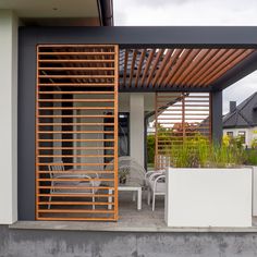 an outdoor patio with wooden slats and chairs