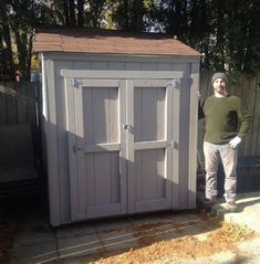 a man standing next to a small shed