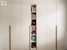 an empty room with white cabinets and bookshelves