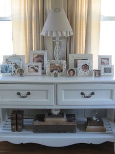 a white dresser with many pictures on it