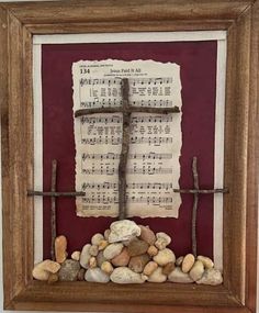 a cross made out of sheet music and rocks