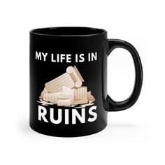 a black coffee mug with the words my life is in ruins on it and an image of