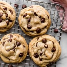 four chocolate chip cookies on a cooling rack