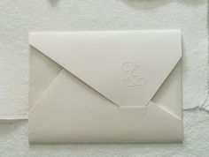 an envelope with a monogrammed letter on the front and bottom is shown in white paper