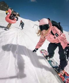 two snowboarders are going down a snowy mountain slope with one person on the board