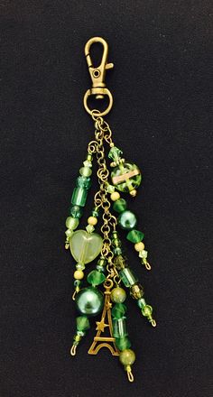 a green beaded keychain with the eiffel tower charm hanging from it