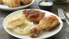 two white plates topped with chicken and biscuits next to a bowl of mashed potatoes