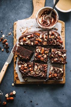 a cutting board topped with brownies and nuts