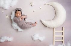 a baby sleeping on top of a cloud next to a crescent moon and star wall decal