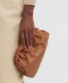 !!!Description---A Mansur Gavriel signature, our sculptural clutch is handcrafted from supple Italian lambskin, featuring an elegantly curved frame with a magnetic closure. Wear it as a clutch, shoulder, crossbody, or belt bag. !!!Fits---iPhone 14 Max and smaller !!!Details---Width: 9.5 in / 24 cmHeight: 5 in / 12.5 cmDepth: 2.75 in / 7 cmStrap drop: 21 in / 53 cm Composition: 100% Italian Lambskin LeatherMade in Italy!!!Materials--- Our Italian lambskin is an ultra-smooth, buttery leather. Lamb Luxury Brown Soft Leather Clutch, Chic Pouch Clutch With Leather Lining, Chic Leather-lined Pouch Clutch, Brown Clutch With Dust Bag, Formal Beige Clutch In Soft Leather, Elegant Brown Textured Leather Clutch, Modern Brown Clutch With Dust Bag Included, Modern Brown Clutch With Dust Bag, Chic Leather Clutch With Smooth Grain