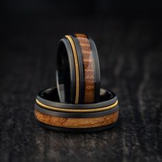 two wedding bands with gold and black wood inlays