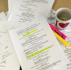 several pieces of paper with writing on them next to a cup of coffee and pen