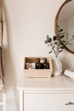 a wooden box with soaps and lotions sits on a dresser next to a mirror