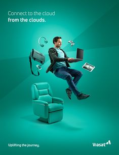 a man sitting on a chair with a laptop in his lap while flying through the air