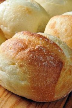 several rolls sitting on top of a wooden cutting board