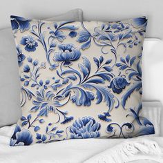 a blue and white pillow sitting on top of a bed