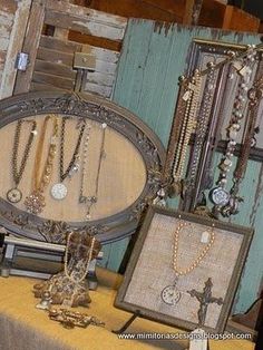 an assortment of necklaces and watches on display in front of a wooden wall with old doors