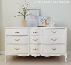 a white dresser with gold handles and drawers