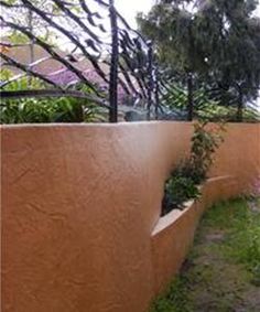 an outside view of a house with trees and plants on the side of the building