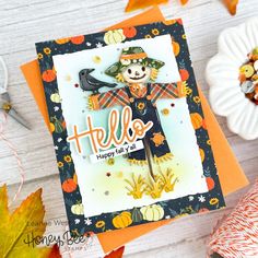 a close up of a card on a table with pumpkins and other autumn decorations