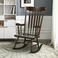 a wooden rocking chair sitting in front of a book shelf