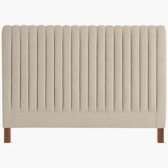 an upholstered headboard with wooden legs and pleated fabric on the top