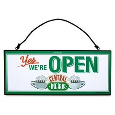 a green and white sign that says, yes we're open central perk