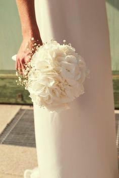 a bride holding a bouquet of white flowers