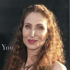 a woman with long red hair wearing a black dress