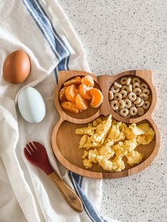 an assortment of breakfast foods laid out on a towel next to eggs and oranges