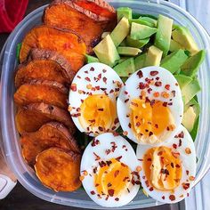 a plastic container filled with hard boiled eggs, avocado and sliced peaches