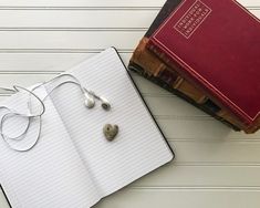 three books are stacked on top of each other with earbuds attached to them