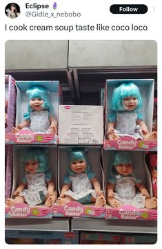 the dolls are in their boxes for sale at the toy store, and they look like they have blue hair