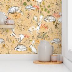 the wallpaper in this kitchen is decorated with birds and flowers, while two vases are