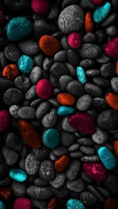 some rocks and pebbles with red, blue, and green colors on them in the dark